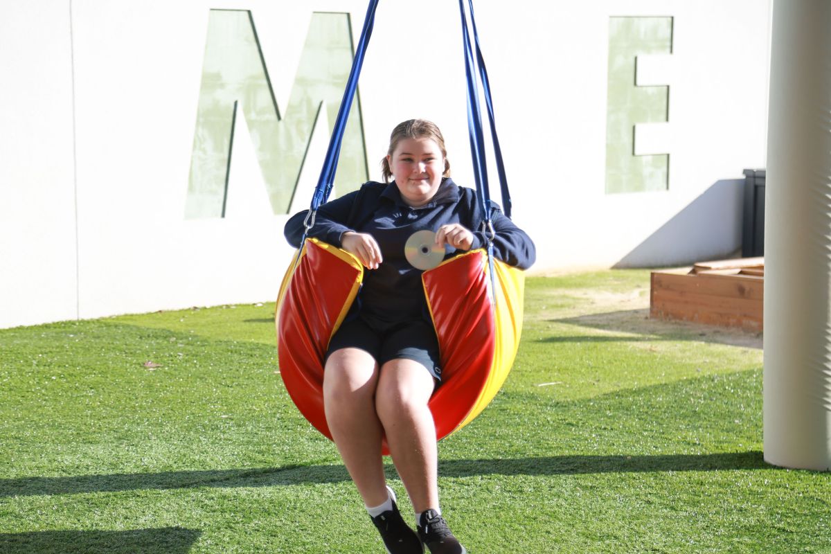 Student using a sensory swing in the playground